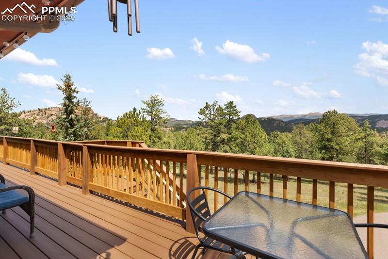 Image 13 of 37: Wooden deck with outdoor dining area and a mountain view