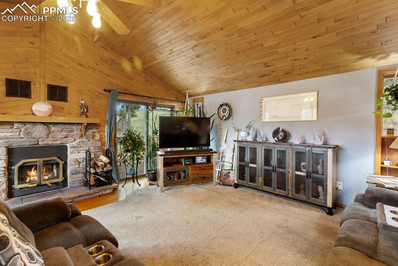 Image 16 of 37: Living area featuring wood ceiling, lofted ceiling, a fireplace, a ceiling