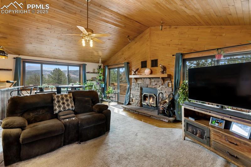 Image 17 of 37: Living area featuring plenty of natural light, a fireplace, wood ceiling, v