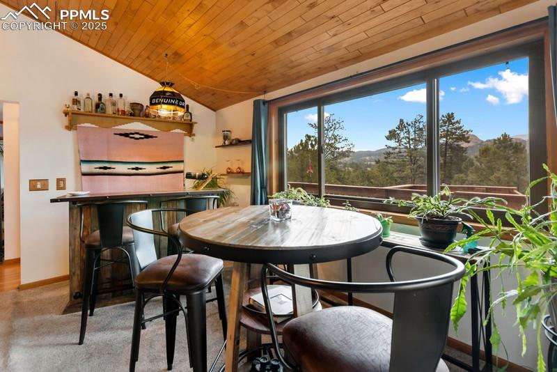 Image 20 of 37: Dining room with lofted ceiling, wood ceiling, and a dry bar