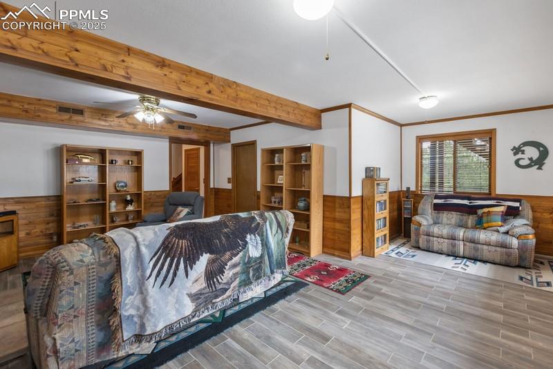 Image 28 of 37: Living room featuring a wainscoted wall, wood walls, wood finish floors, a