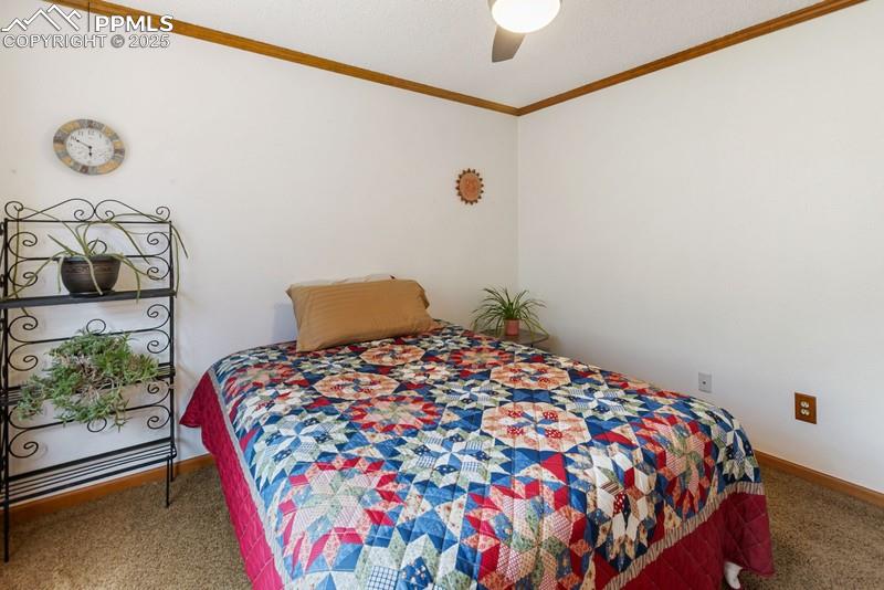 Image 37 of 37: Carpeted bedroom with ornamental molding, ceiling fan, and a textured ceili