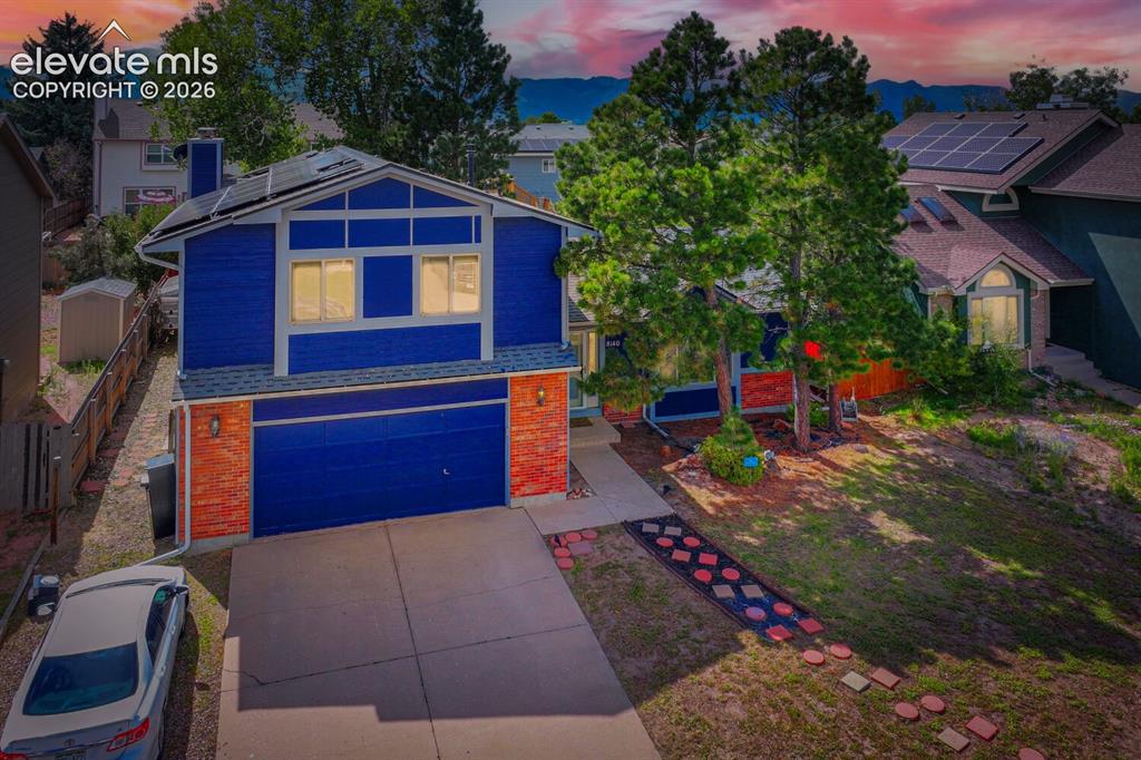 Image 1 of 42: Two-story residence featuring a bold blue siding, integrated solar panels,