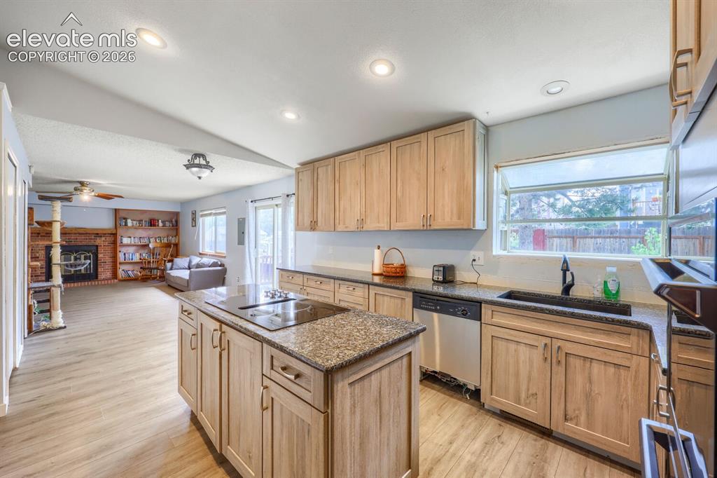 Image 11 of 42: Kitchen with wood-finish cabinetry, granite countertops, and stainless stee