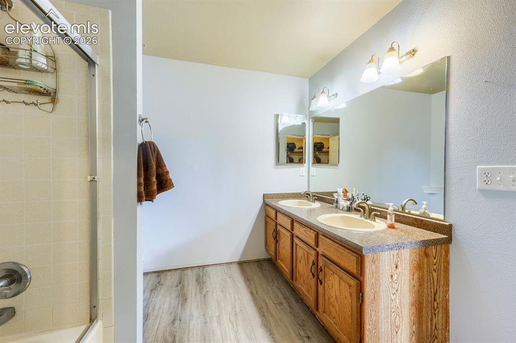 Image 17 of 42: Dual vanity with integrated sinks, expansive wall mirror, wood-finish cabin