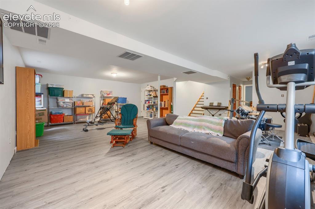 Image 17 of 42: Spacious lower-level room featuring wood-finish flooring, recessed lighting