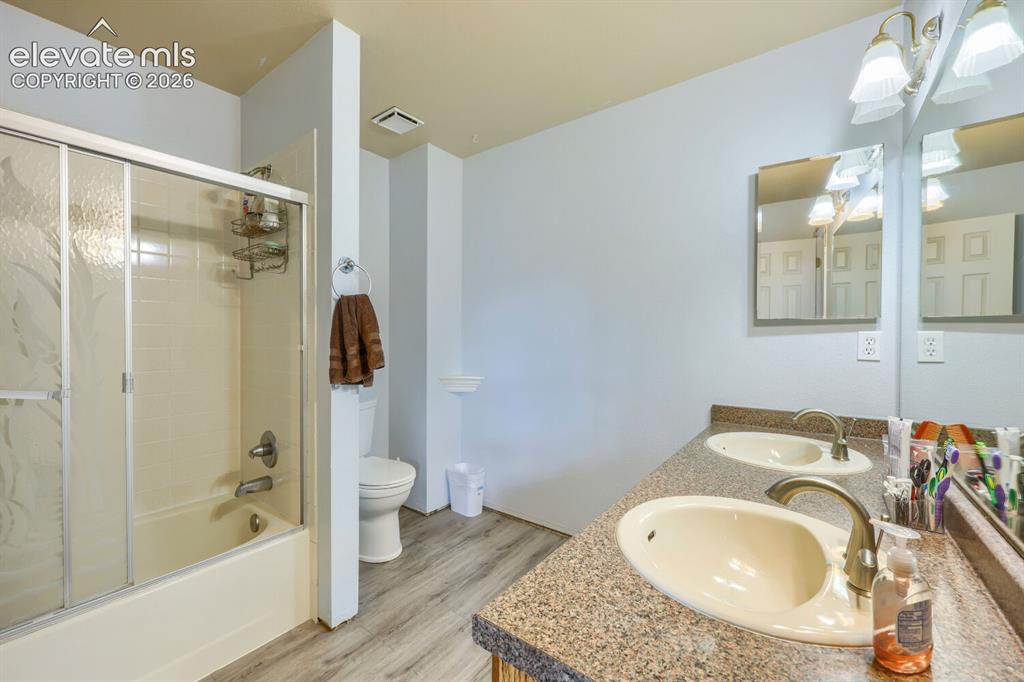 Image 18 of 42: Dual vanity with integrated sinks and a speckled countertop