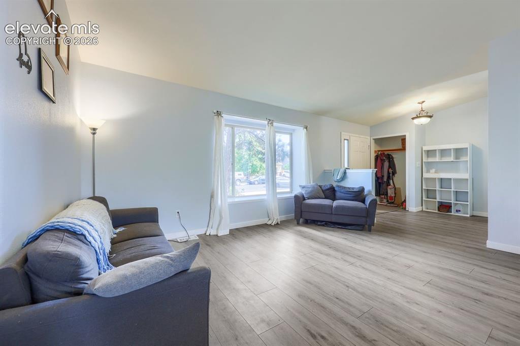 Image 20 of 42: Wood-finish flooring, light-colored walls, multiple windows, and a built-in