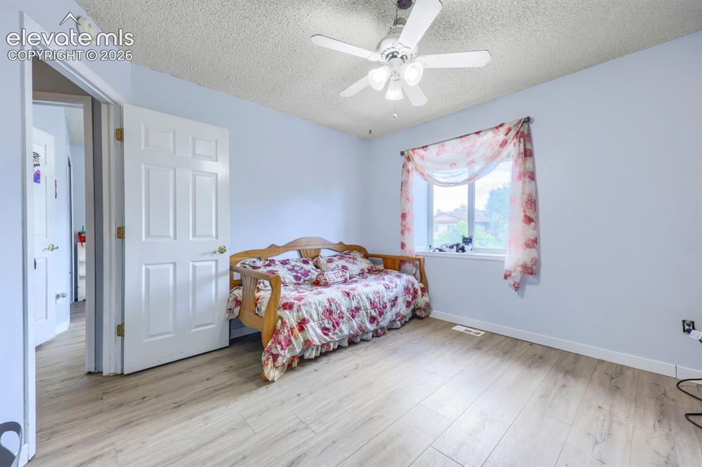 Image 21 of 42: LVP flooring, white paneled door, ceiling fan with integrated lighting, and