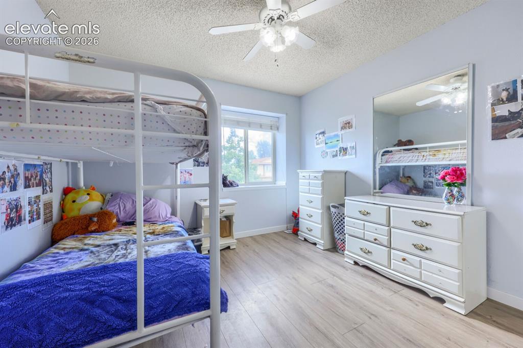 Image 22 of 42: LVP flooring, ceiling fan, and window offering natural light