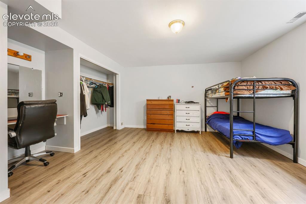 Image 24 of 42: basement bedroom with LVP flooring, recessed lighting, and a built-in close