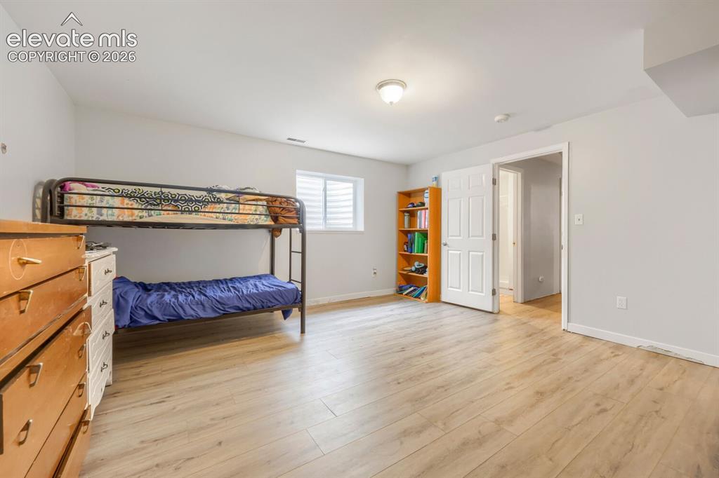Image 25 of 42: basement bedroom with LVP flooring throughout, neutral painted walls, and a