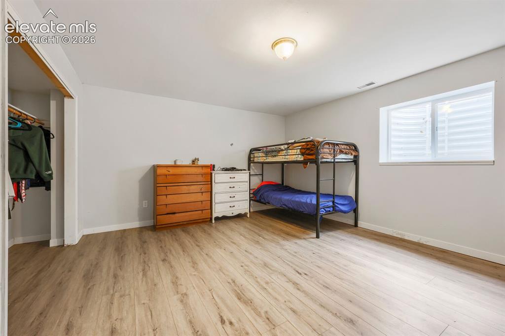 Image 26 of 42: basement bedroom with LVP flooring, recessed window, overhead lighting, and