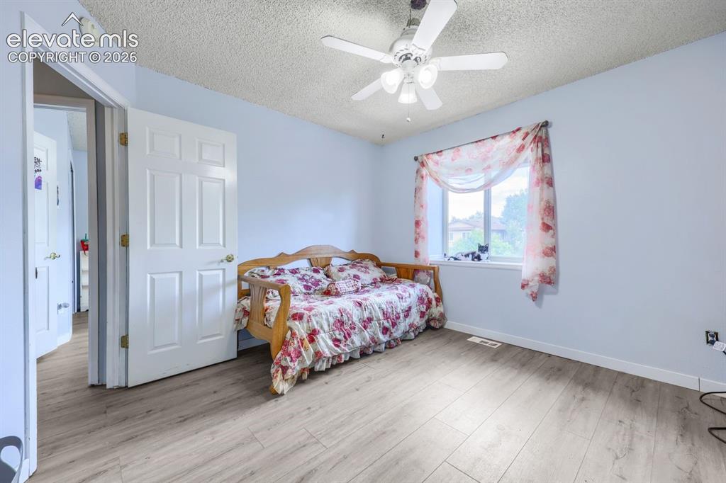 Image 30 of 42: Light-toned wood-finish flooring, white paneled interior doors, and a ceili