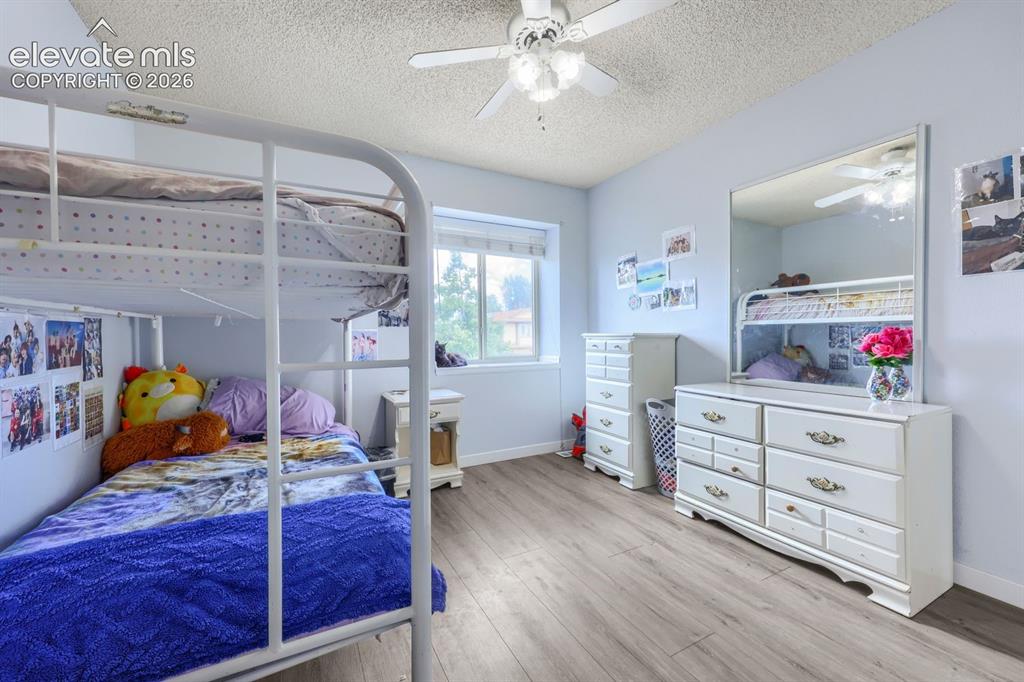 Image 31 of 42: Wood-finish flooring, ceiling fan, and window providing natural light