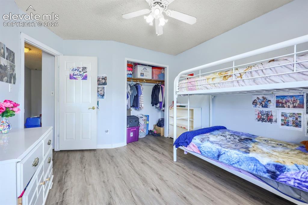 Image 32 of 42: Wood-finish flooring throughout, ceiling fan with light fixture, and an ope