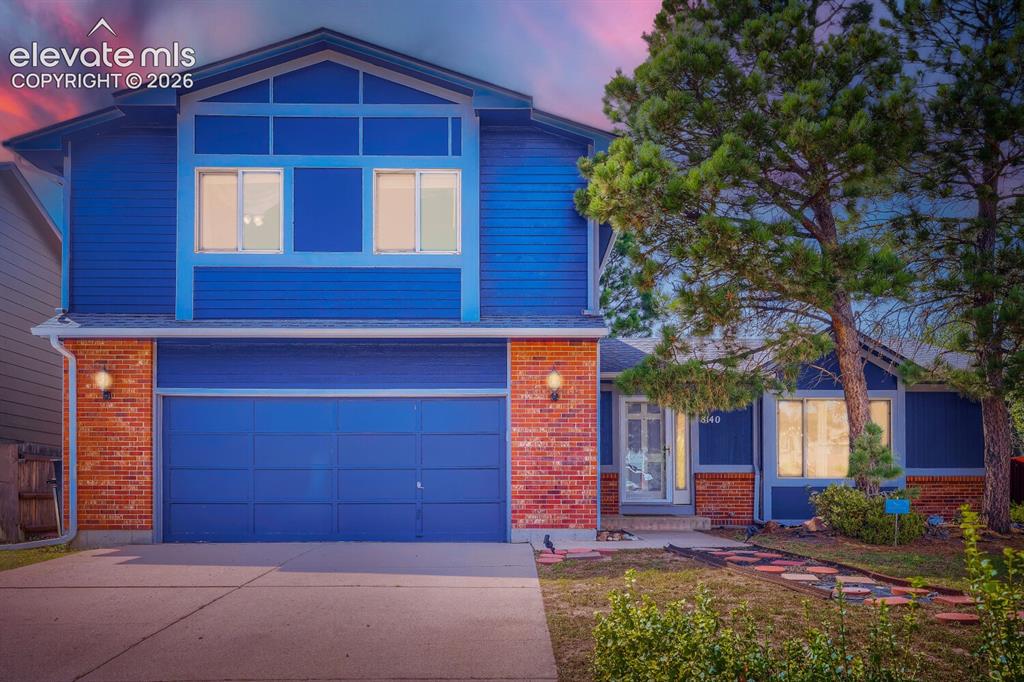Image 35 of 42: Two-story exterior with blue siding and brick accents