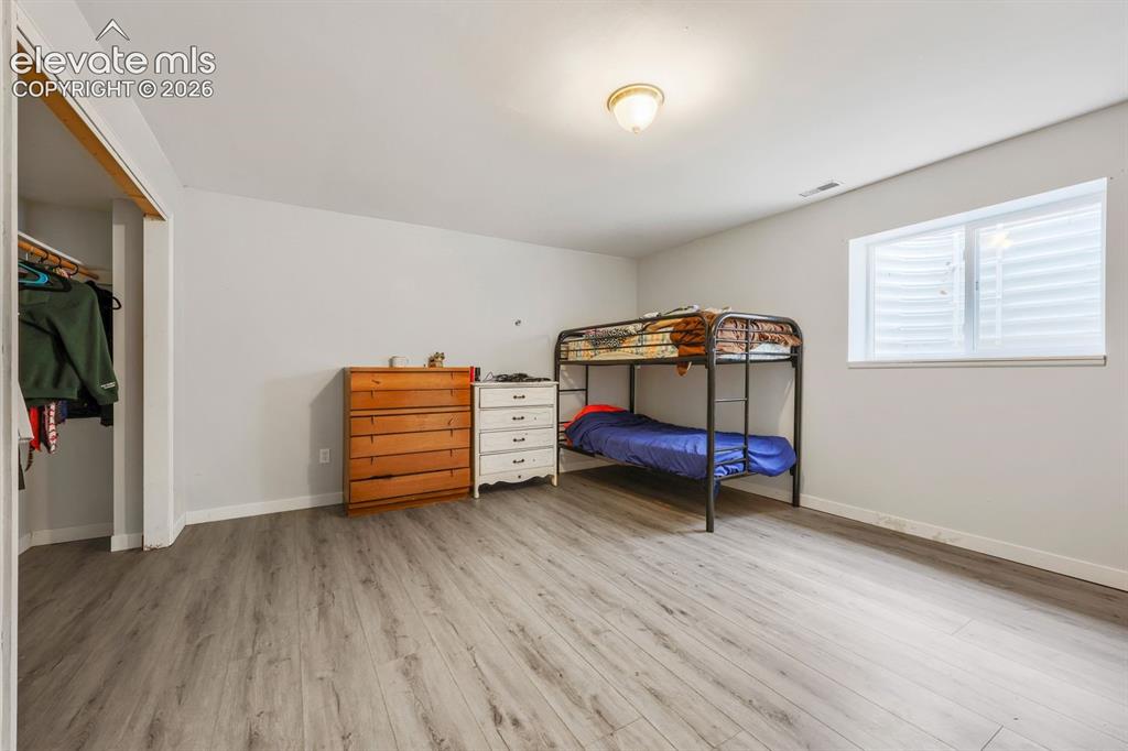 Image 35 of 42: Spacious room featuring wood-finish flooring, a functional window, and an o