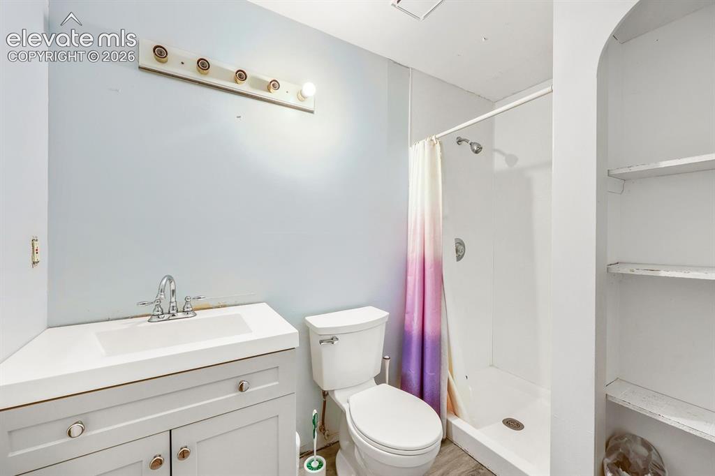Image 37 of 42: Corner vanity with integrated rectangular sink and chrome faucet