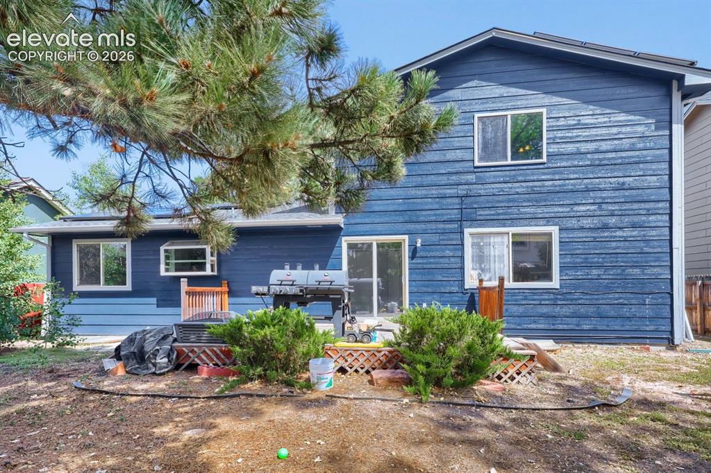 Image 38 of 42: Blue horizontal siding exterior with multiple windows and a sliding glass d