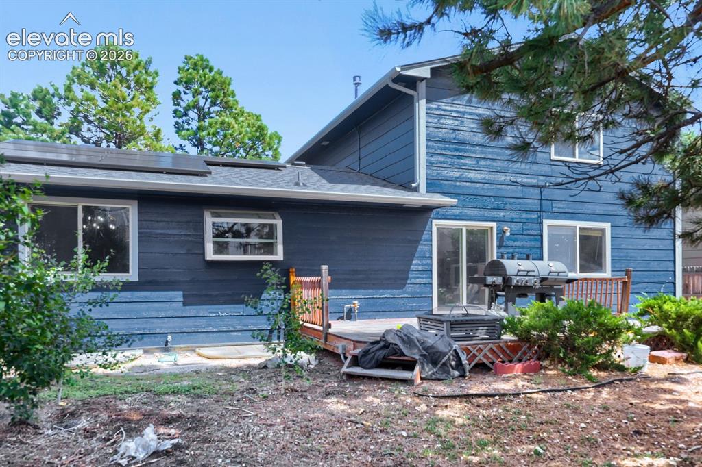 Image 39 of 42: Rear exterior featuring wood siding, multiple windows, a sliding glass door
