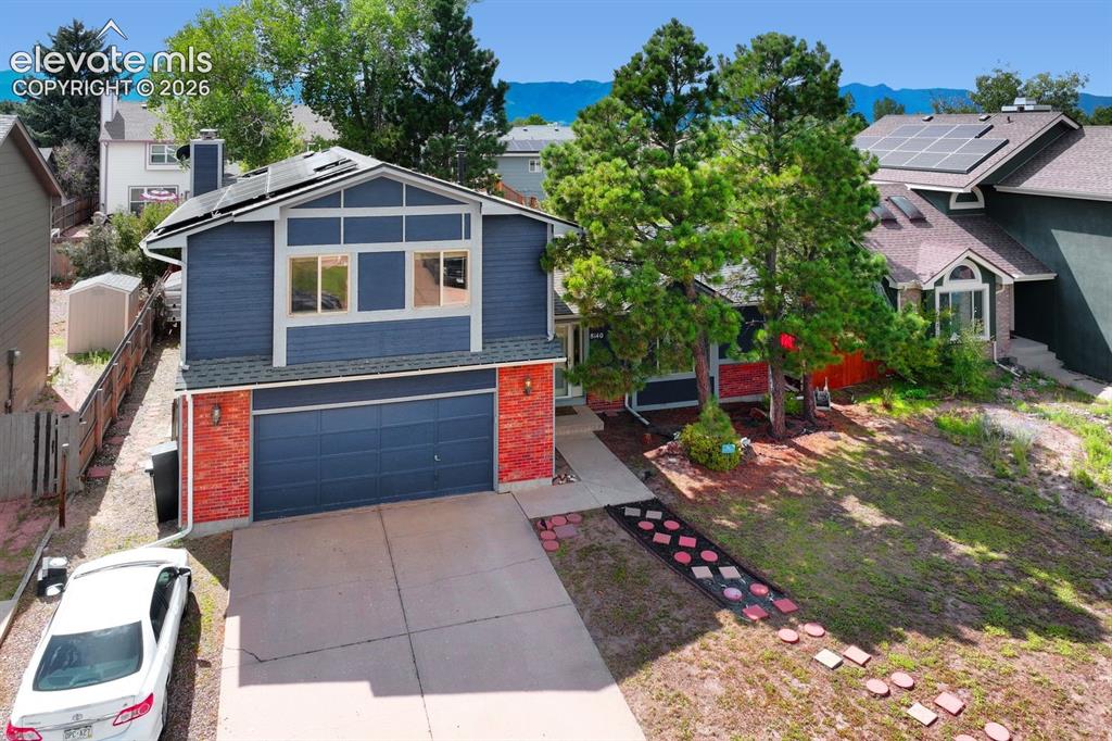 Image 4 of 42: Contemporary exterior with blue siding and brick accents