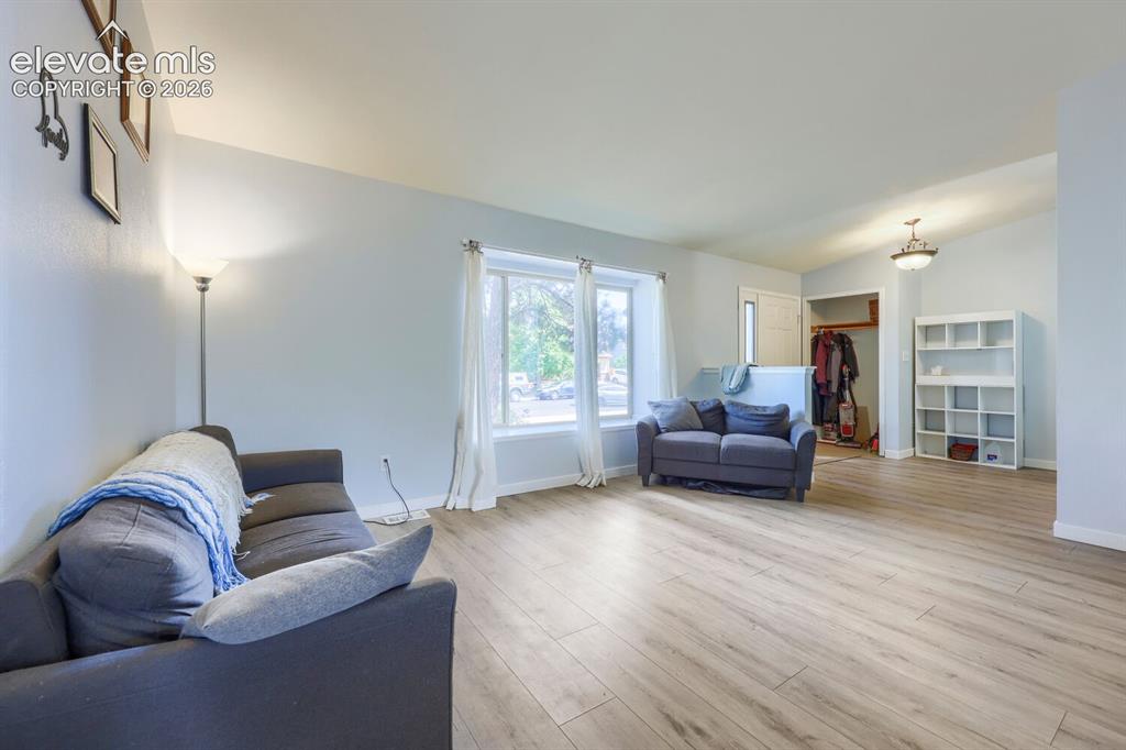 Image 5 of 42: Spacious open-concept main level living room featuring light wood-finish fl