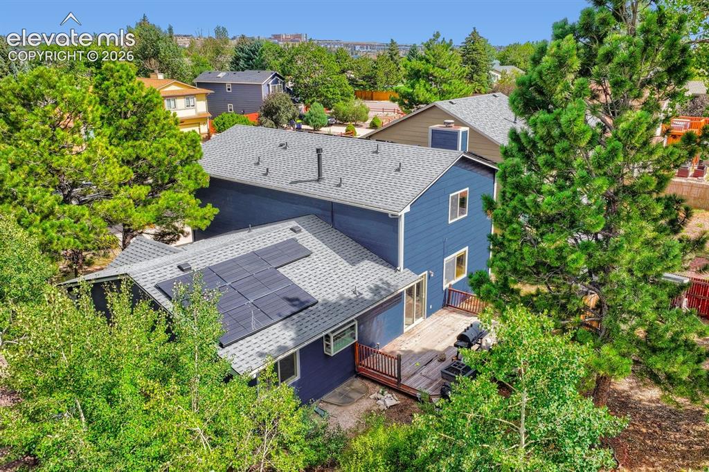 Image 6 of 42: Two-story exterior with blue siding, a multi-level roofline, and integrated