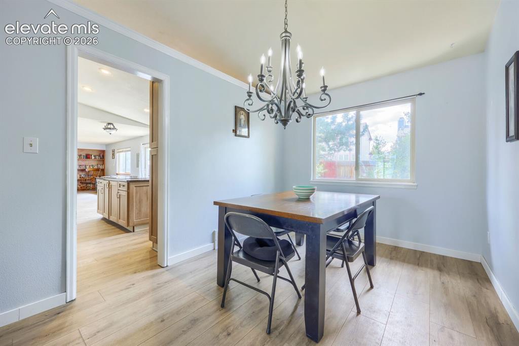 Image 7 of 42: LVP flooring throughout, with a classic chandelier providing overhead light