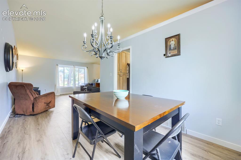 Image 8 of 42: LVP flooring throughout, with a classic chandelier providing overhead illum