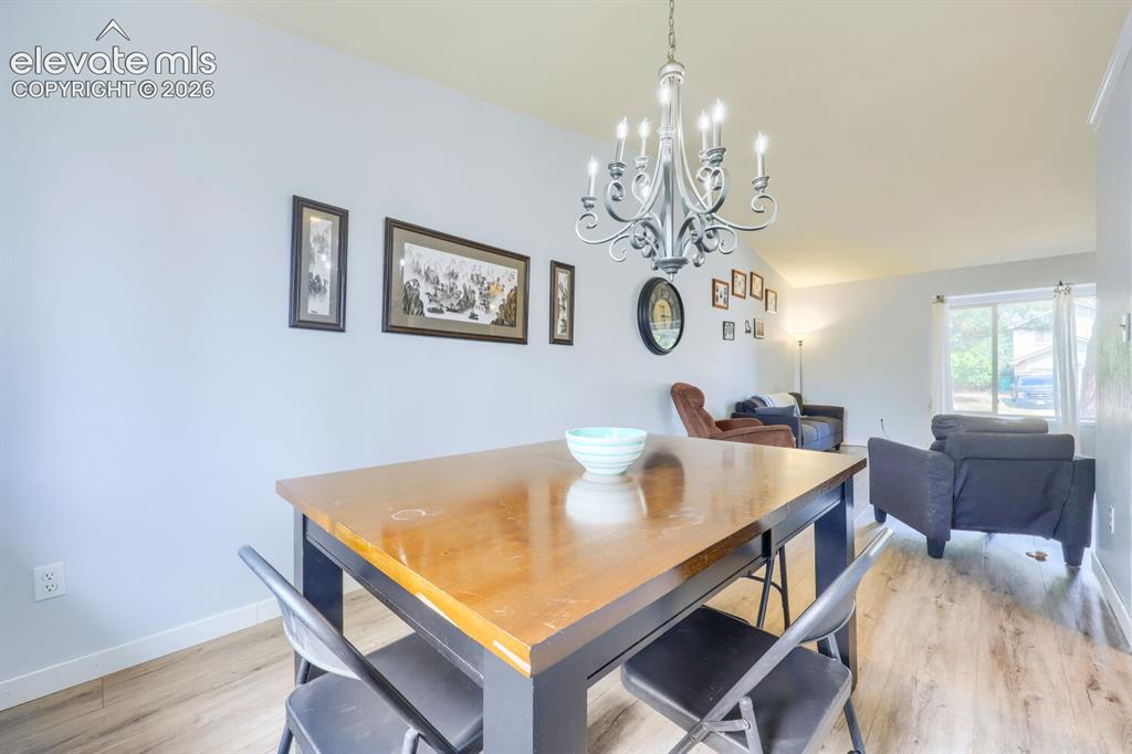 Image 9 of 42: LVP flooring throughout, light gray wall color, and a multi-arm chandelier