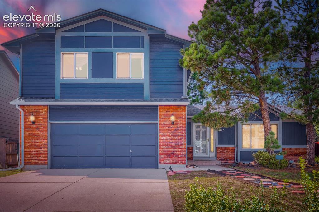 Image 9 of 42: Two-story exterior with blue siding and brick accents