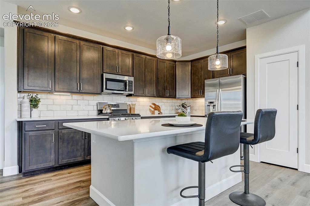 Image 10 of 37: Elegant, dark-stained cabinetry gives the kitchen a contemporary touch.