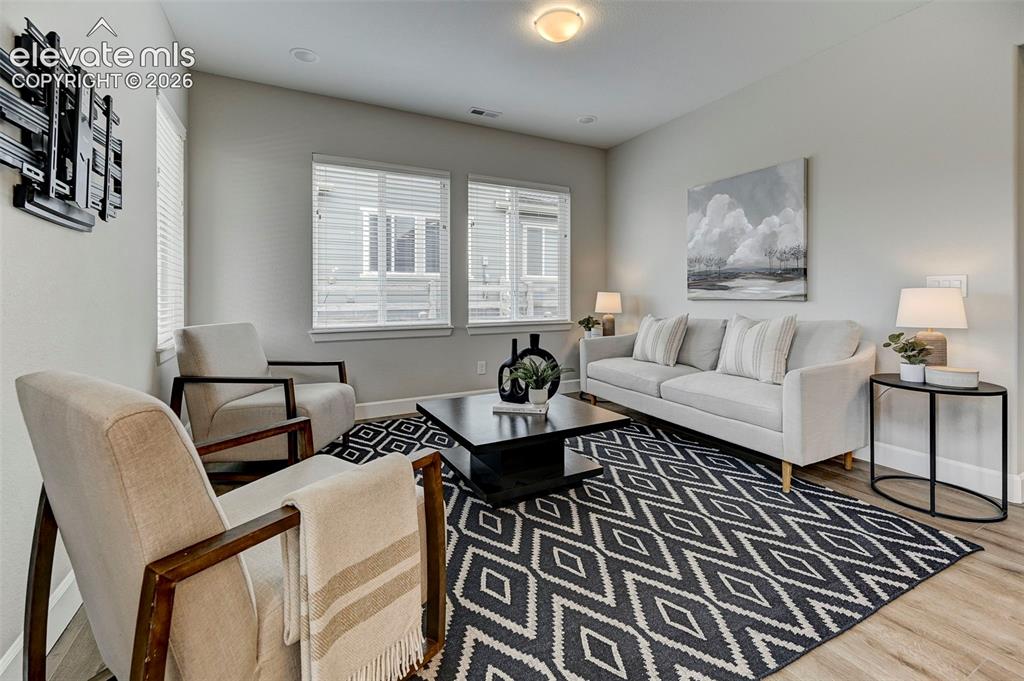 Image 12 of 37: The spacious living room features luxury vinyl plank floors and plenty of s