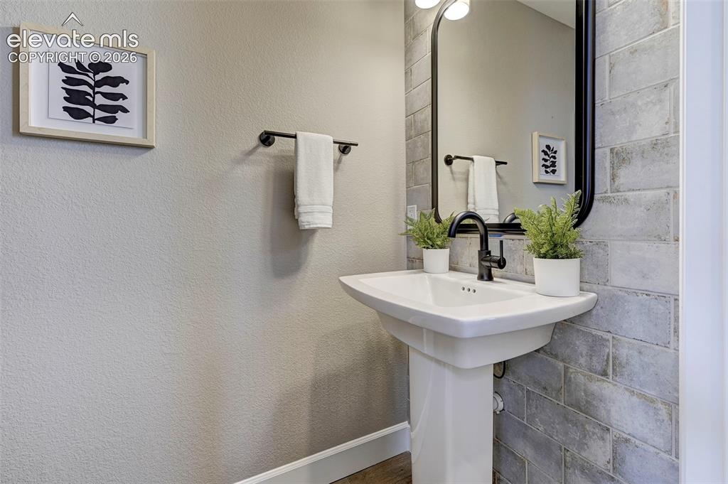 Image 15 of 37: This main floor powder bath has an elegant feature wall and a pedestal sink