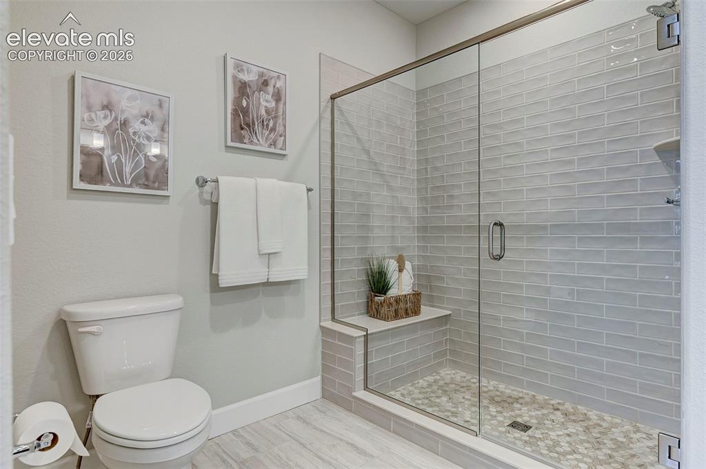 Image 20 of 37: The star of the primary bath is this glass-enclosed shower with a subway ti