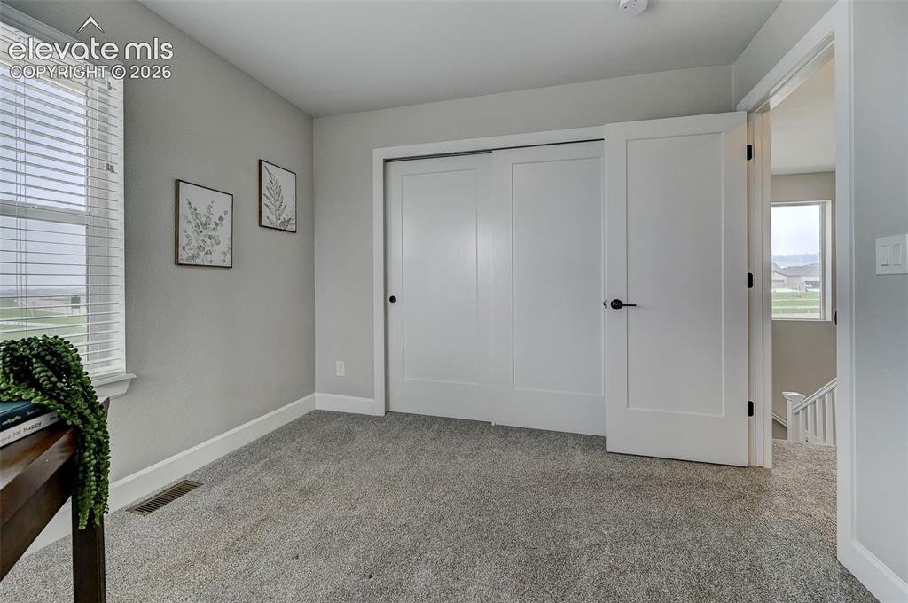 Image 29 of 37: The second bedroom is located on the upper leval and features an double rea