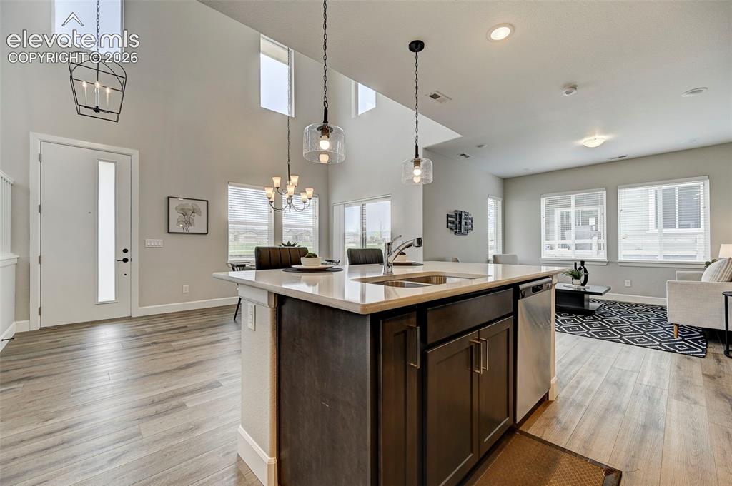 Image 6 of 37: The kitchen is open to the living area, dining area and entry. With quartz