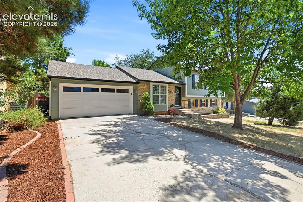 Image 1 of 50: Split-level residence featuring a two-car garage with windowed doors