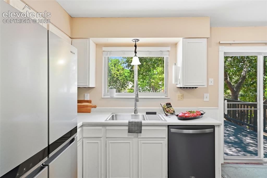 Image 12 of 50: Kitchen with white cabinetry, light-toned countertops, and a stainless stee