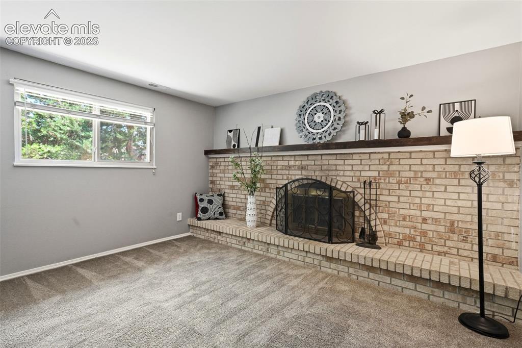 Image 17 of 50: Brick fireplace with an arched firebox and a substantial wood mantle