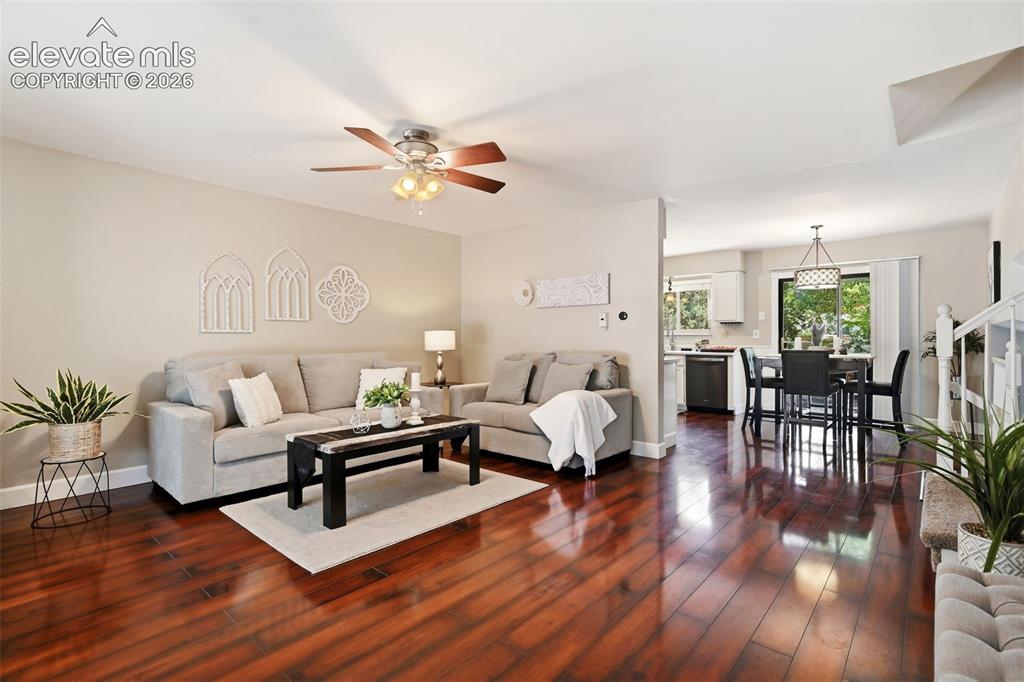Image 2 of 50: Open-concept living space featuring wood-finish flooring, a ceiling fan wit