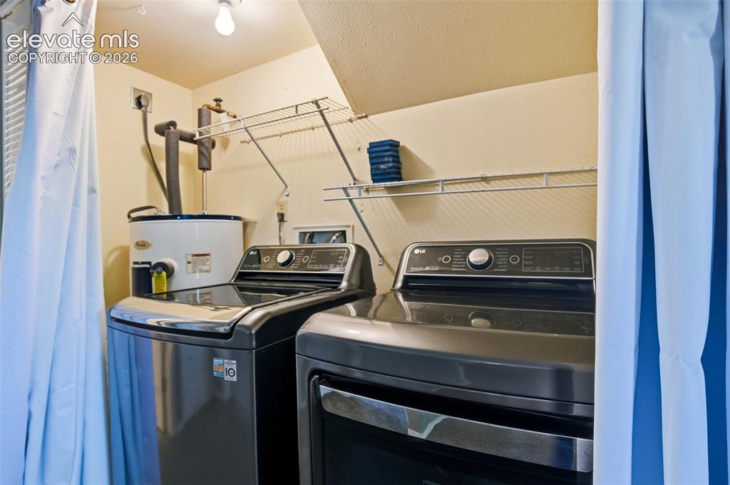 Image 20 of 50: Dedicated laundry area featuring a white water heater, overhead wire shelvi