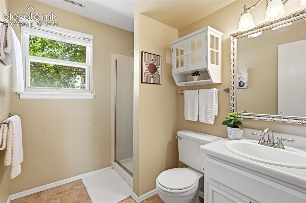 Image 21 of 50: Bathroom featuring a walk-in shower with glass enclosure, single vanity wit