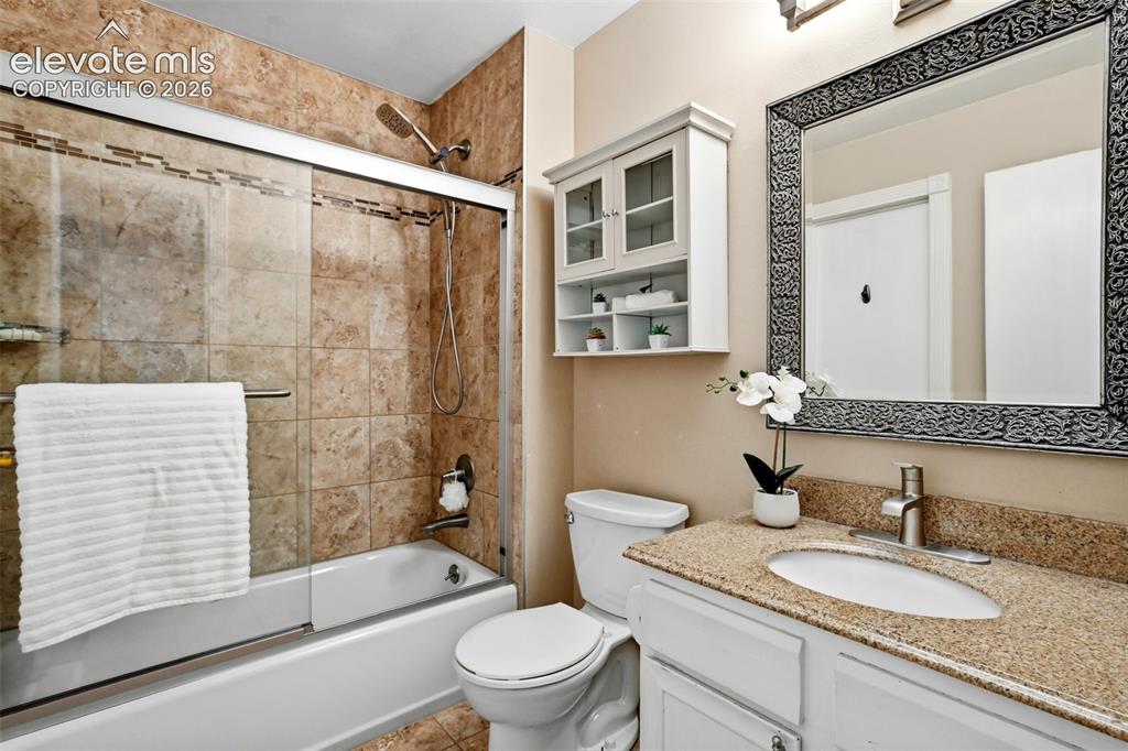 Image 24 of 50: Bathroom featuring a tub and shower combination with full-height tile surro