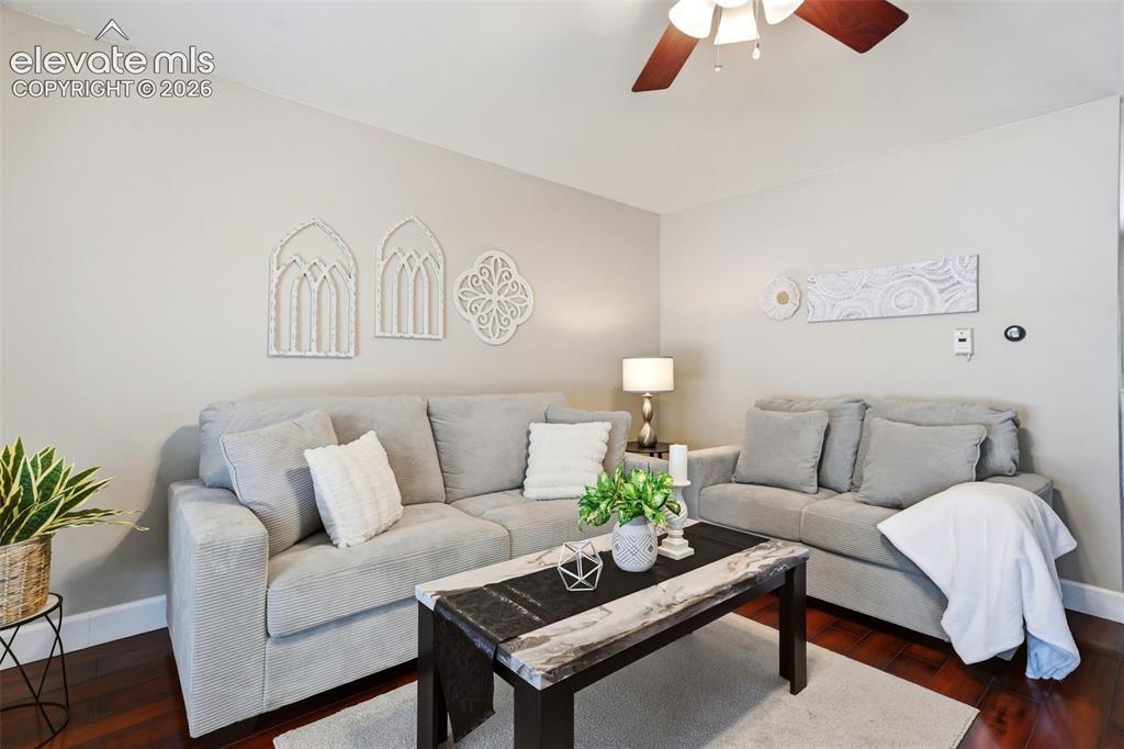 Image 3 of 50: Living area featuring warm gray wall paint, dark wood-finish flooring, whit