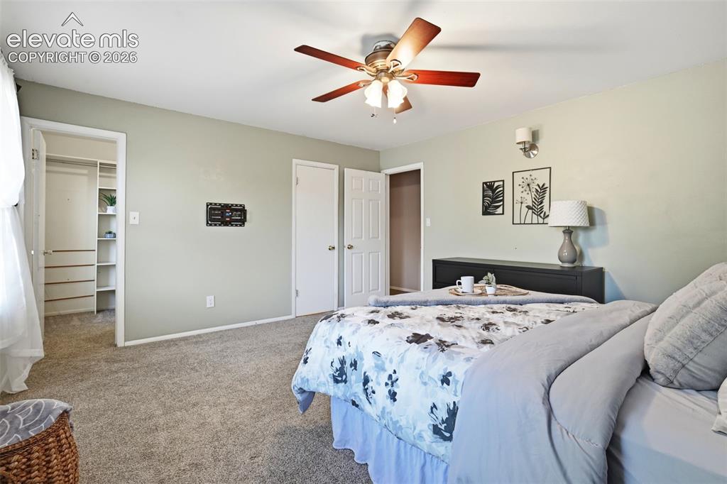 Image 31 of 50: Spacious bedroom featuring neutral carpeting, a ceiling fan with integrated