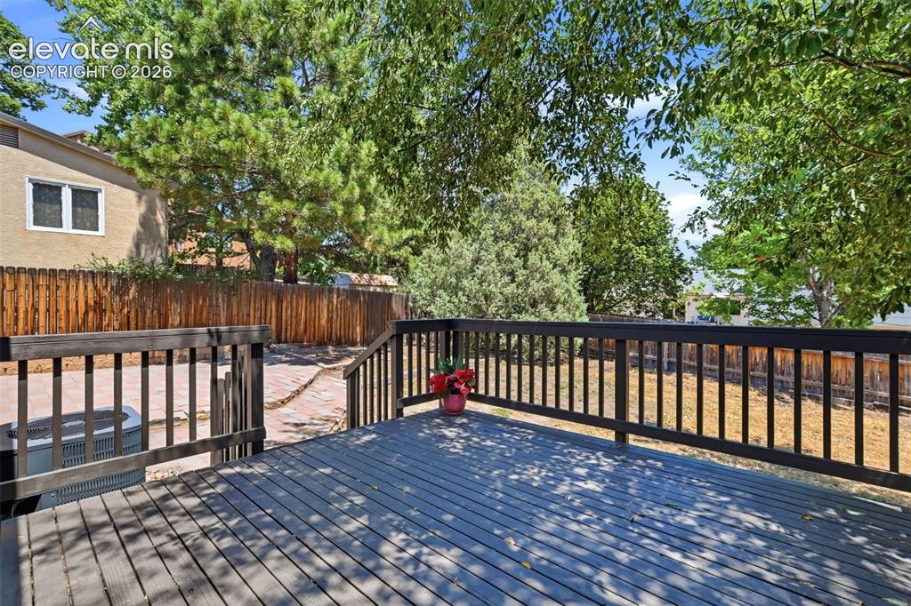 Image 34 of 50: Expansive exterior deck featuring dark wood railing and steps