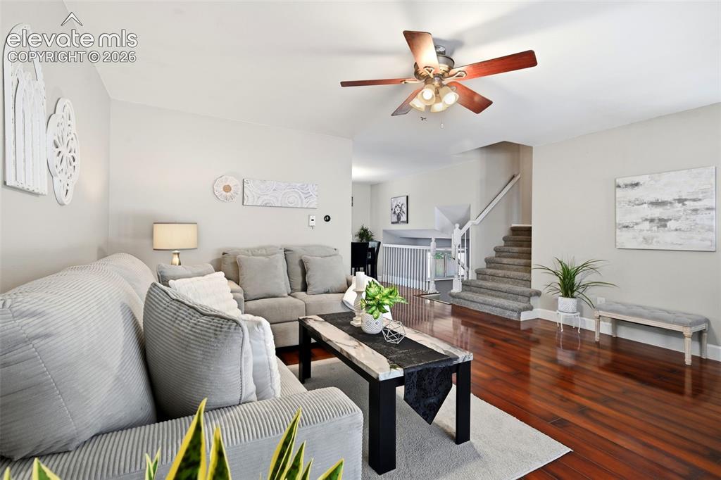 Image 4 of 50: Living area featuring rich wood-finish flooring, light neutral wall tones,