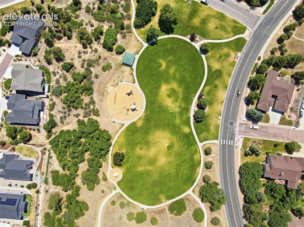 Image 44 of 50: Expansive green space featuring a large manicured lawn, established walking